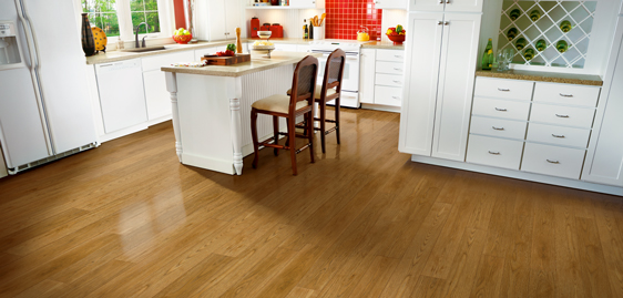 Light hardwood floor in kitchen with white cabinets